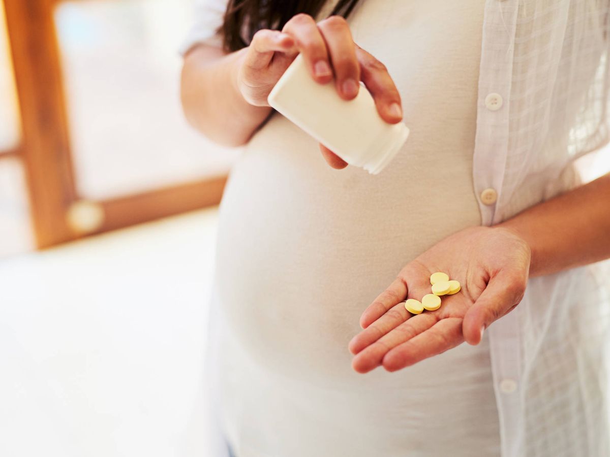 Foto: Una mujer embarazada tomando pastillas (Foto: iStock)