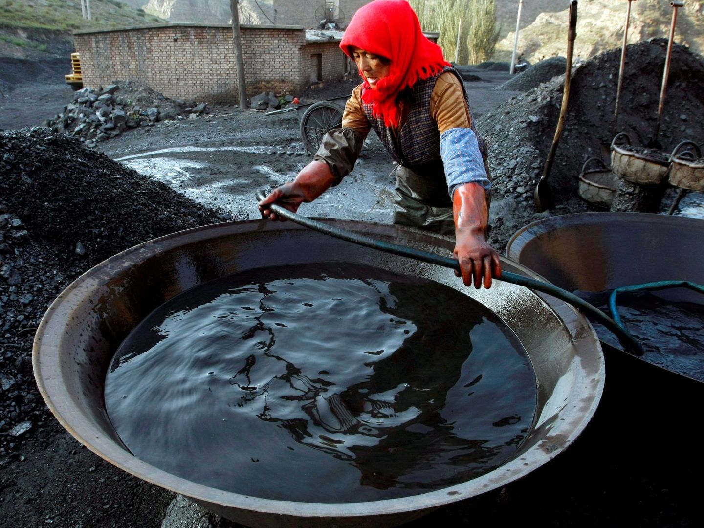 Una empleada lava carbón para limpiarlo de impurezas en una pequeña mina privada en China. Foto: EFE Archivo Michael Reynolds