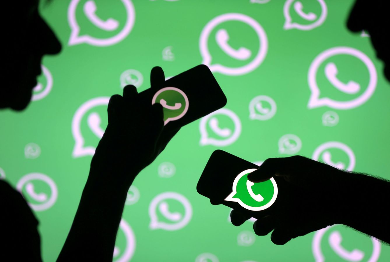 FILE PHOTO: Men pose with smartphones in front of displayed Whatsapp logo in this illustration September 14, 2017. REUTERS Dado Ruvic File Photo