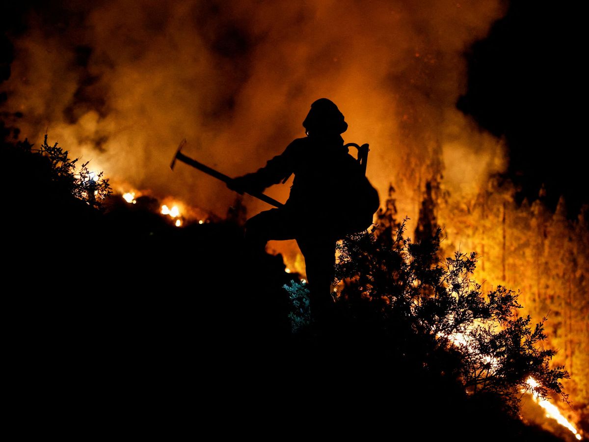 Foto: Un bombero en Arafo (Tenerife) intentando contener la expansión de las llamas. (Reuters/Borja Suárez)