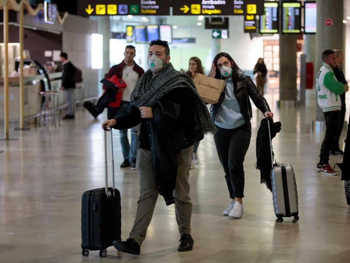 Foto: Pasajeros con mascarilla en el aeropuerto de Manises, en Valencia. (EFE)