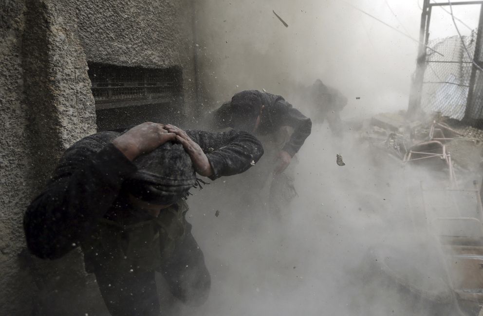 Combatientes rebeldes alcanzados por el proyectil de un tanque en Damasco (Reuters). 