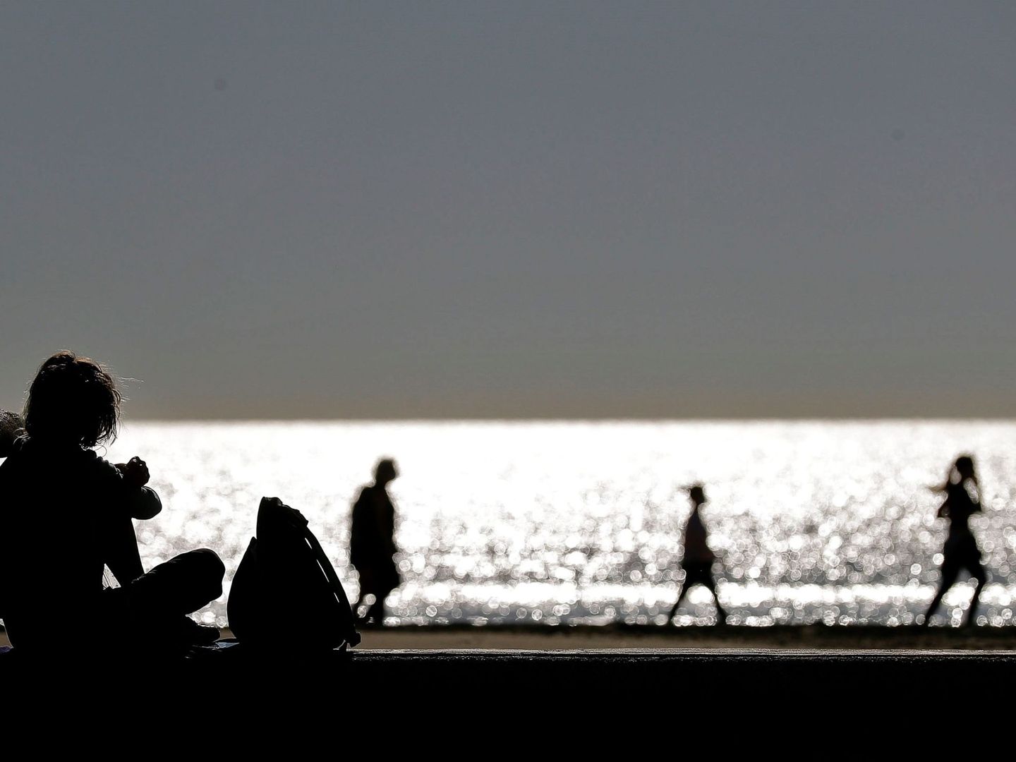 Varias personas disfrutan de un paseo a primera hora en la playa de la Malvarrosa, Valencia, el pasado 11 de mayo. (EFE)