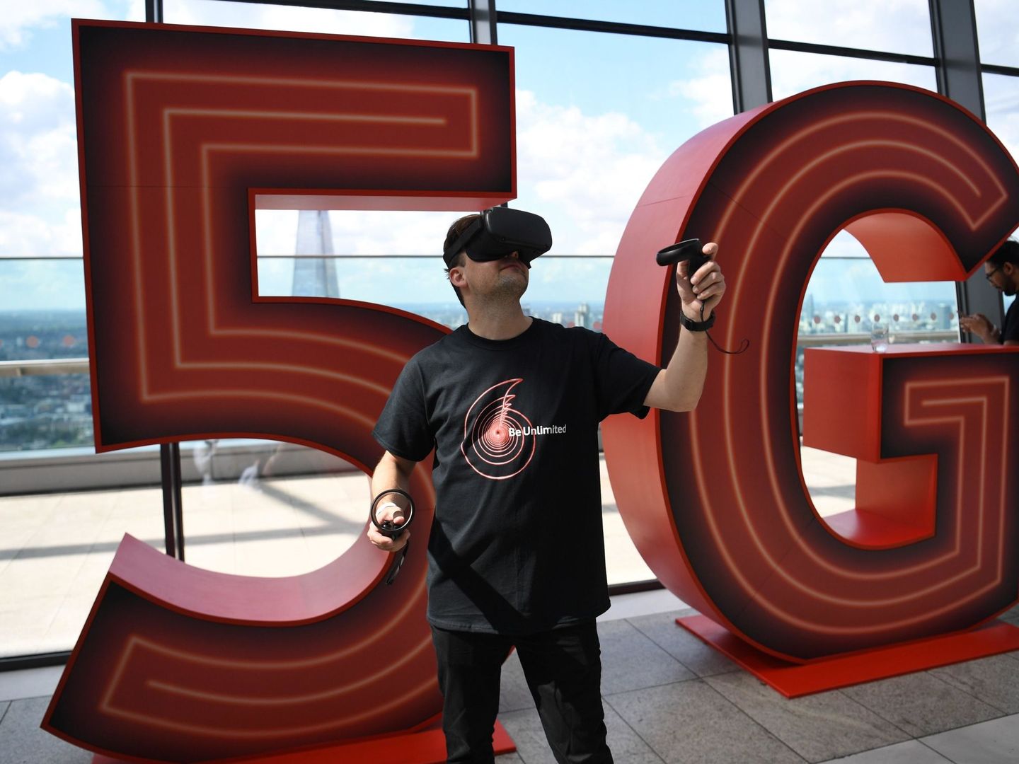 NGH15. London (United Kingdom), 03 07 2019.- A man uses a virtual reality headset as 5G branding is displayed at a press conference in London, Britain, 03 July 2019. Vodaphone launched their 5G service in the UK. (Reino Unido, Londres) EFE EPA NEIL H