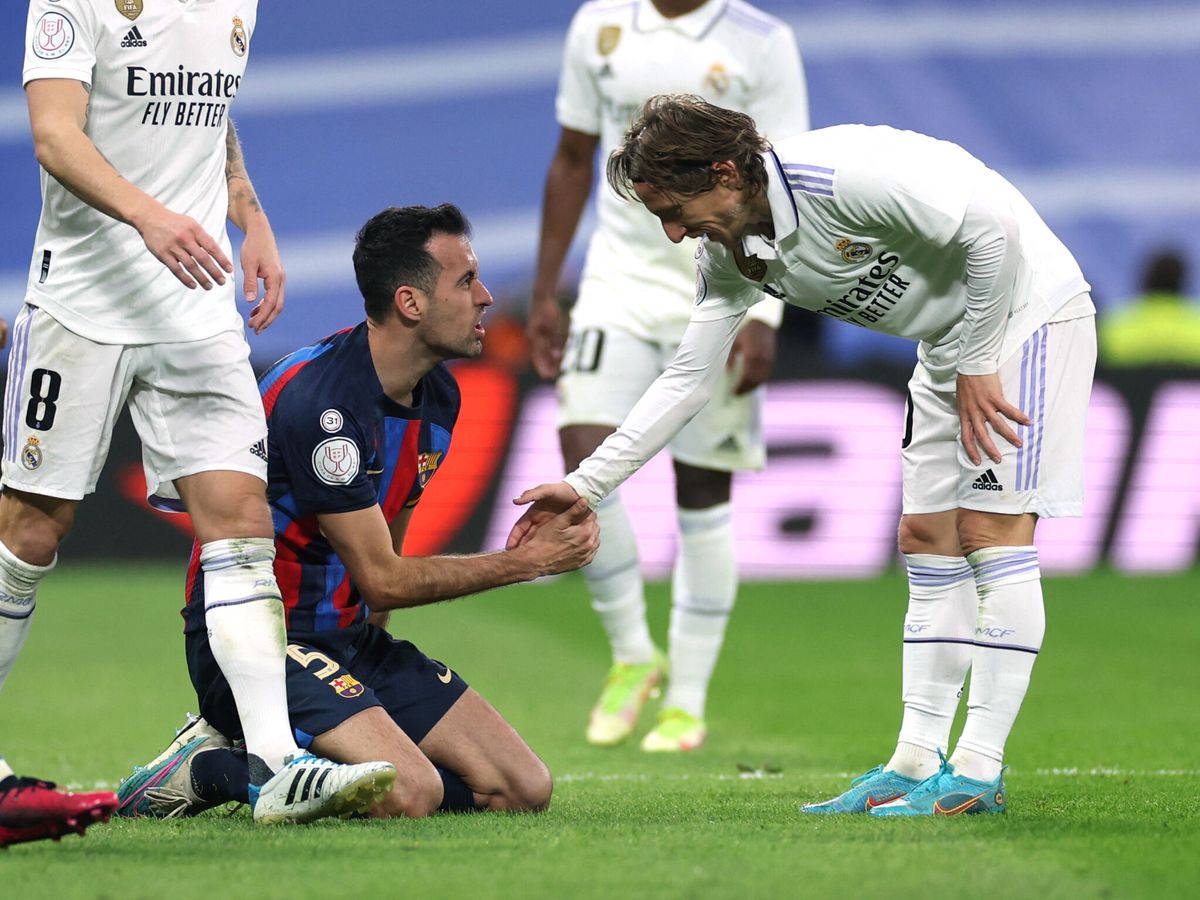 Foto: Modric ayuda a Busquets a levantarse. (Reuters/Isabel Infantes)