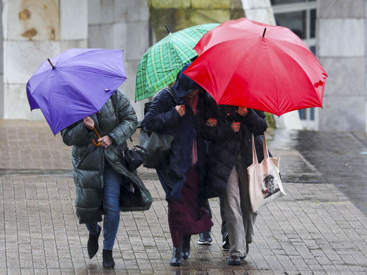 Foto: Varias personas se protegen de la lluvia (EFE/Xoán Rey)