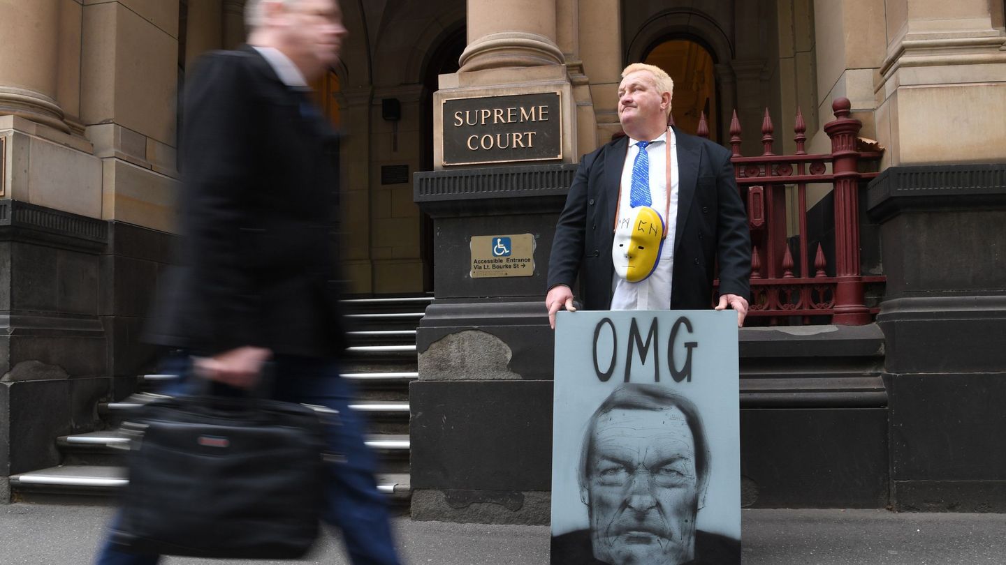 Un manifestante sostiene una pancarta frente al Tribunal Supremo de Victoria donde aparece el cardenal George Pell, en Melbourne, Australia. (Efe)