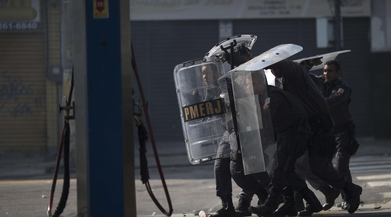 Un grupo de policías se protege en una favela (AP)