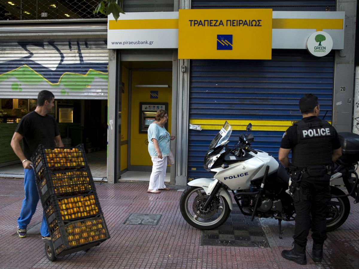 Foto: Una mujer junto a un cajero cerrado en Atenas. (Reuters/Djurica)
