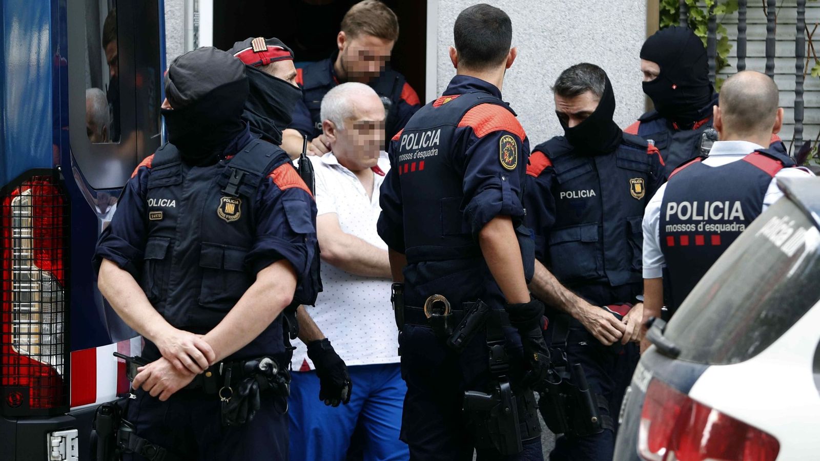 Foto: Los Mossos d'Esquadra trasladan del domicilio en la calle Torrent d'en Grau de Badalona (Barcelona), a uno de los detenidos durante la operación policial contra la mafia armenia. (EFE)