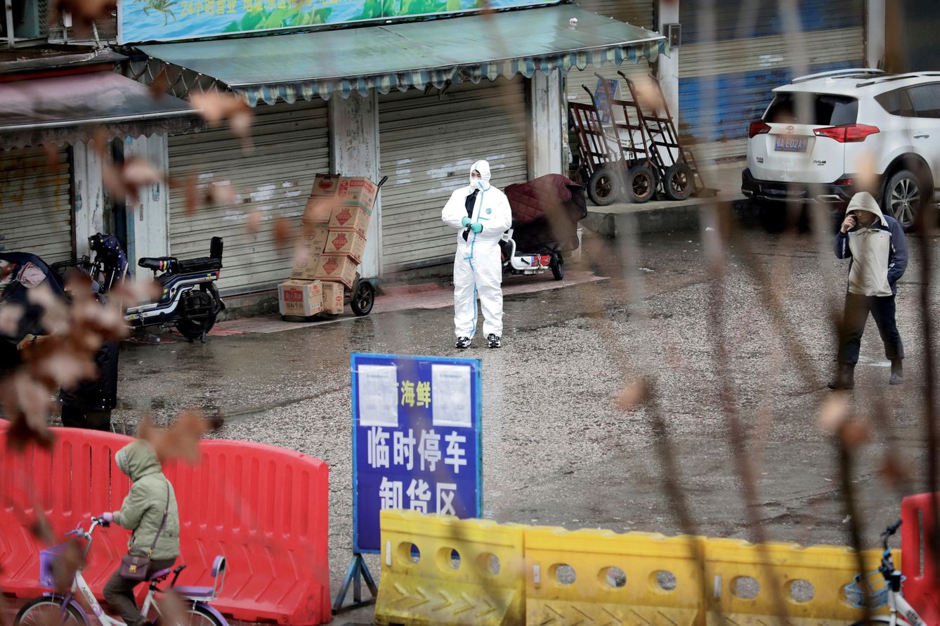 Un trabajador, frente a una tienda cerrada en un mercado de Wuhan. (Reuters)