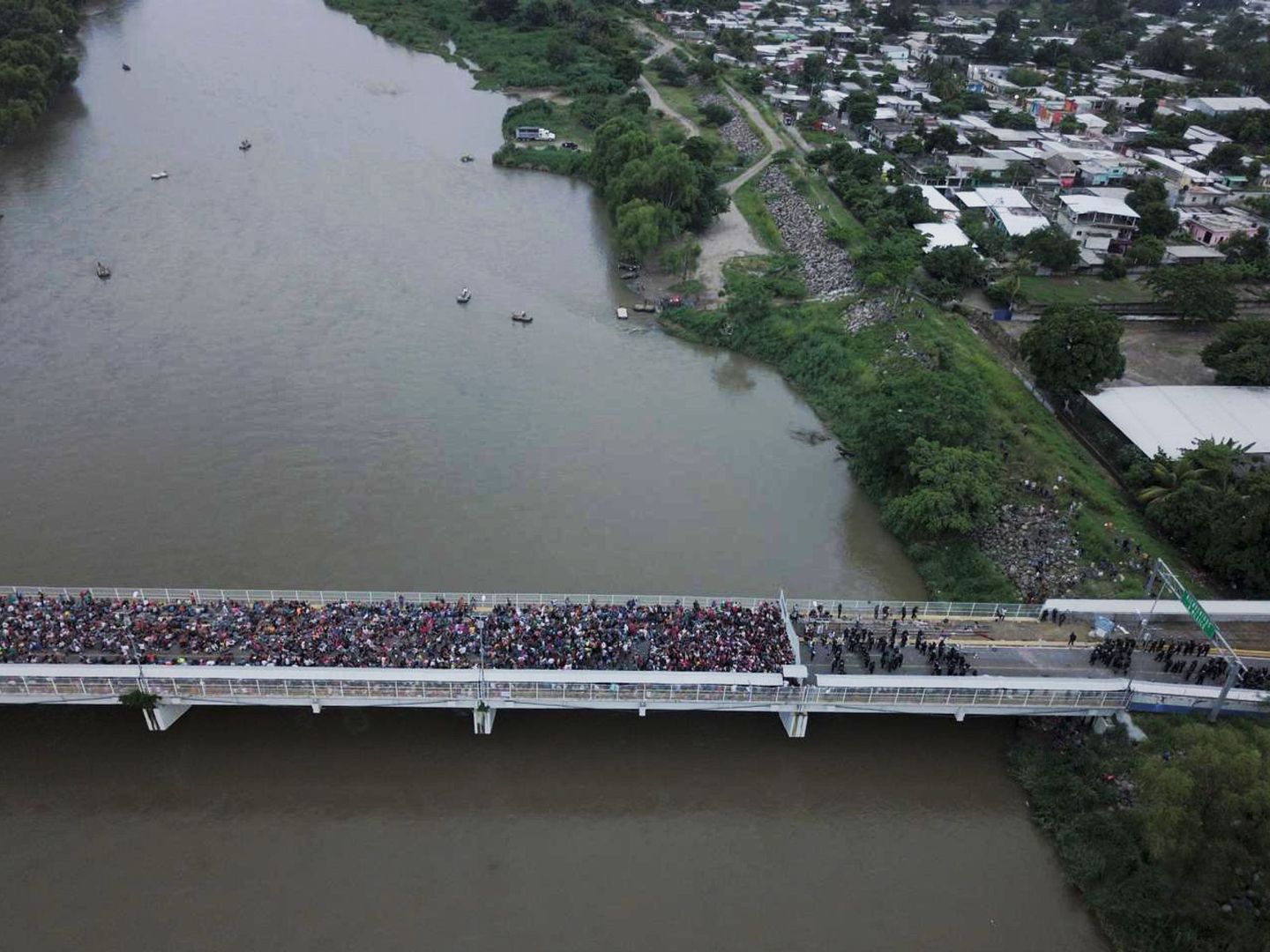 Cientos de migrantes hondureños que permanecen varados en uno de los puentes que separan Guatemala y México. (EFE)