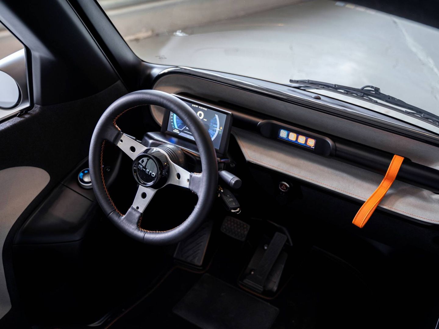 Instrumentación digital y volante sin airbag. A la derecha se ve el tirador de la puerta frontal.