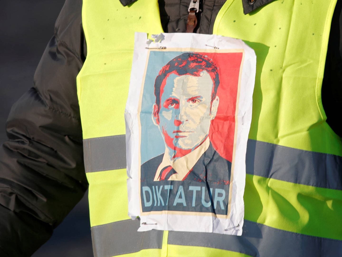 A man wearing a yellow vest, a symbol of a French drivers' protest against higher fuel prices, attends the demonstration with an image of French president Emmanuel Macron, in Paris, France, November 17, 2018. REUTERS/Charles Platiau - RC14923CF5E0