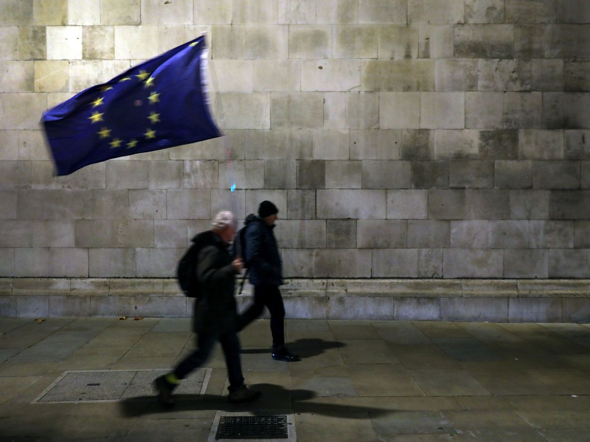 Foto: Un manifestante camina con una bandera europea. (Reuters)