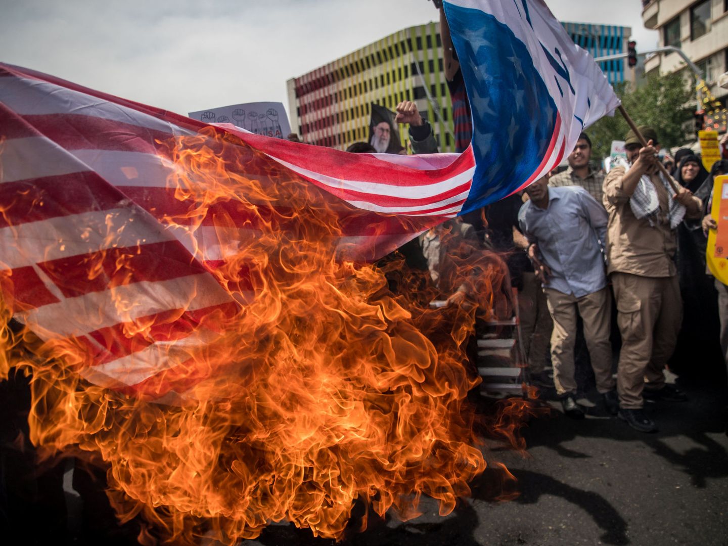 Manifestantes iraníes queman banderas de EEUU como protesta por su retirada del acuerdo nuclear, en Teherán, el 11 de mayo de 2018. (Reuters)