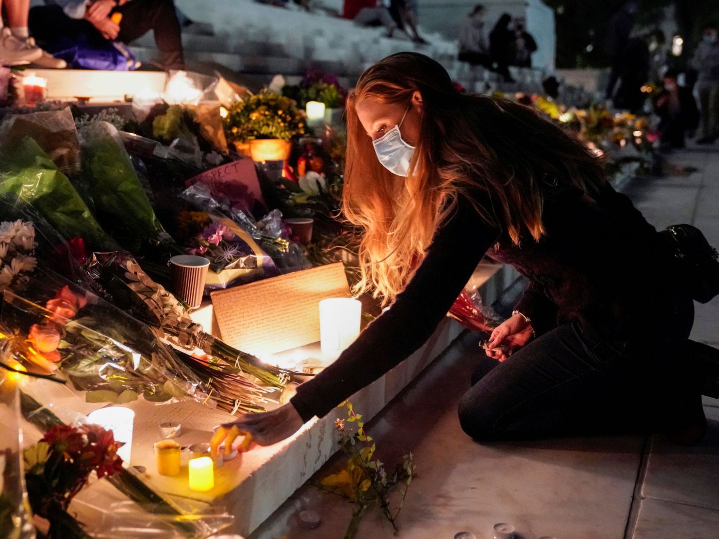 Una mujer enciende una vela por la muerte de Ruth Bader Ginsburg. (Reuters)