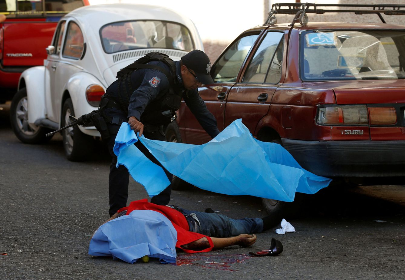 Un policía cubre el cadáver de un hombre asesinado por asaltantes desconocidos en Chilpancingo, Guerrero, el 15 de noviembre de 2017. (Reuters)