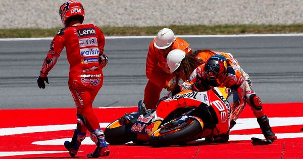 Foto: Jorge Lorenzo intenta levantar su moto frente a Andrea Dovizioso. (EFE)