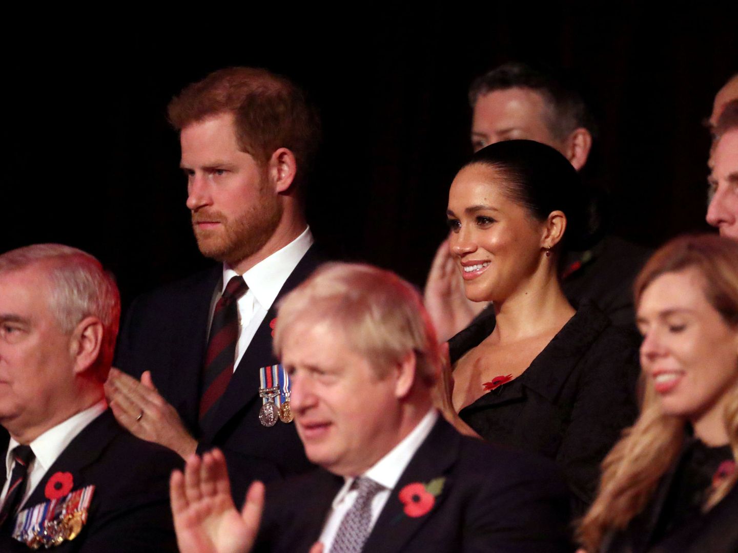 Harry, con gesto serio mientras aplaude junto a Meghan Markle. (Reuters)
