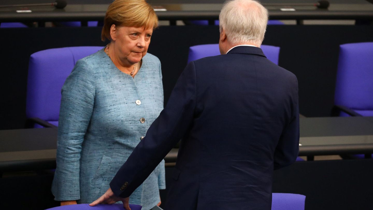 Merkel conversa con Seehofer en el Parlamento alemán. (Reuters)