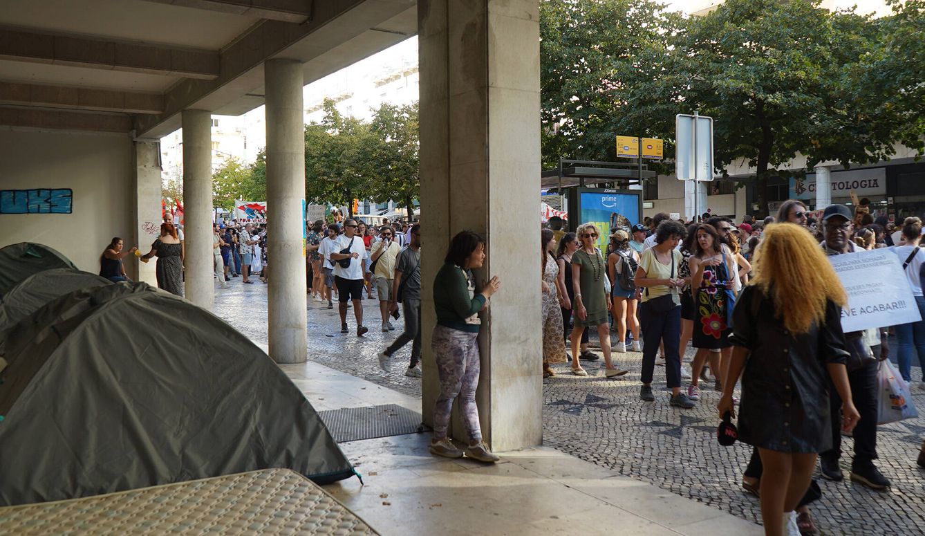 Una persona acampada contempla una manifestación por la vivienda. (J.R.)