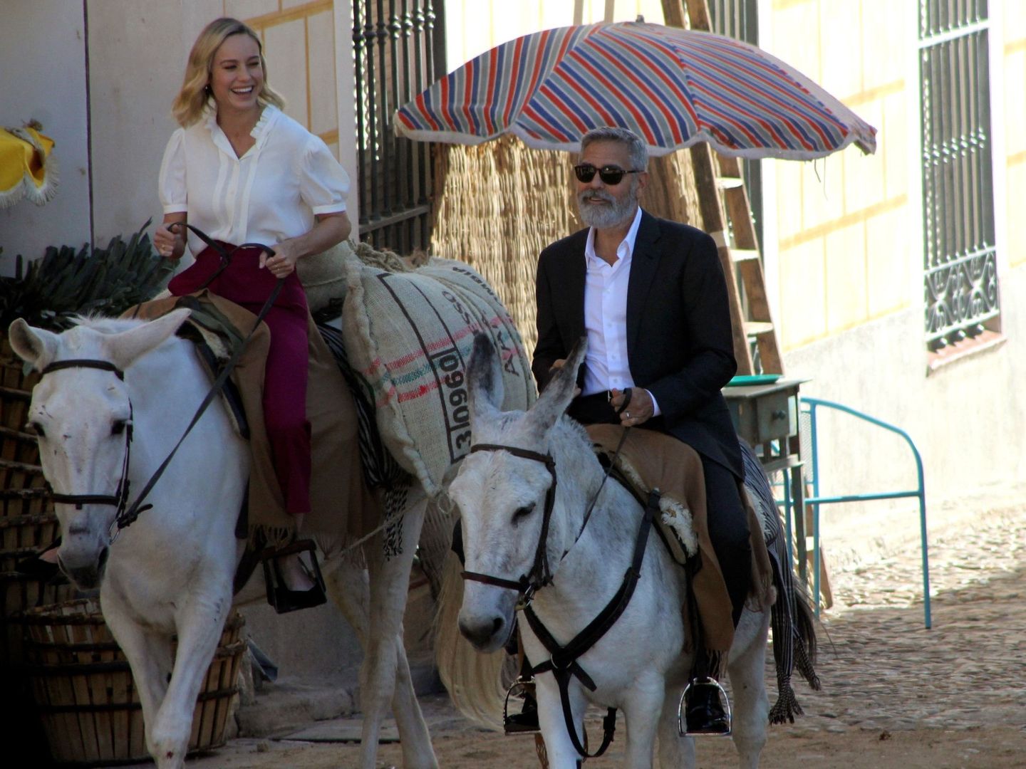 George Clooney, a lomos de un burro, junto a la actriz Brie Larson. (EFE)