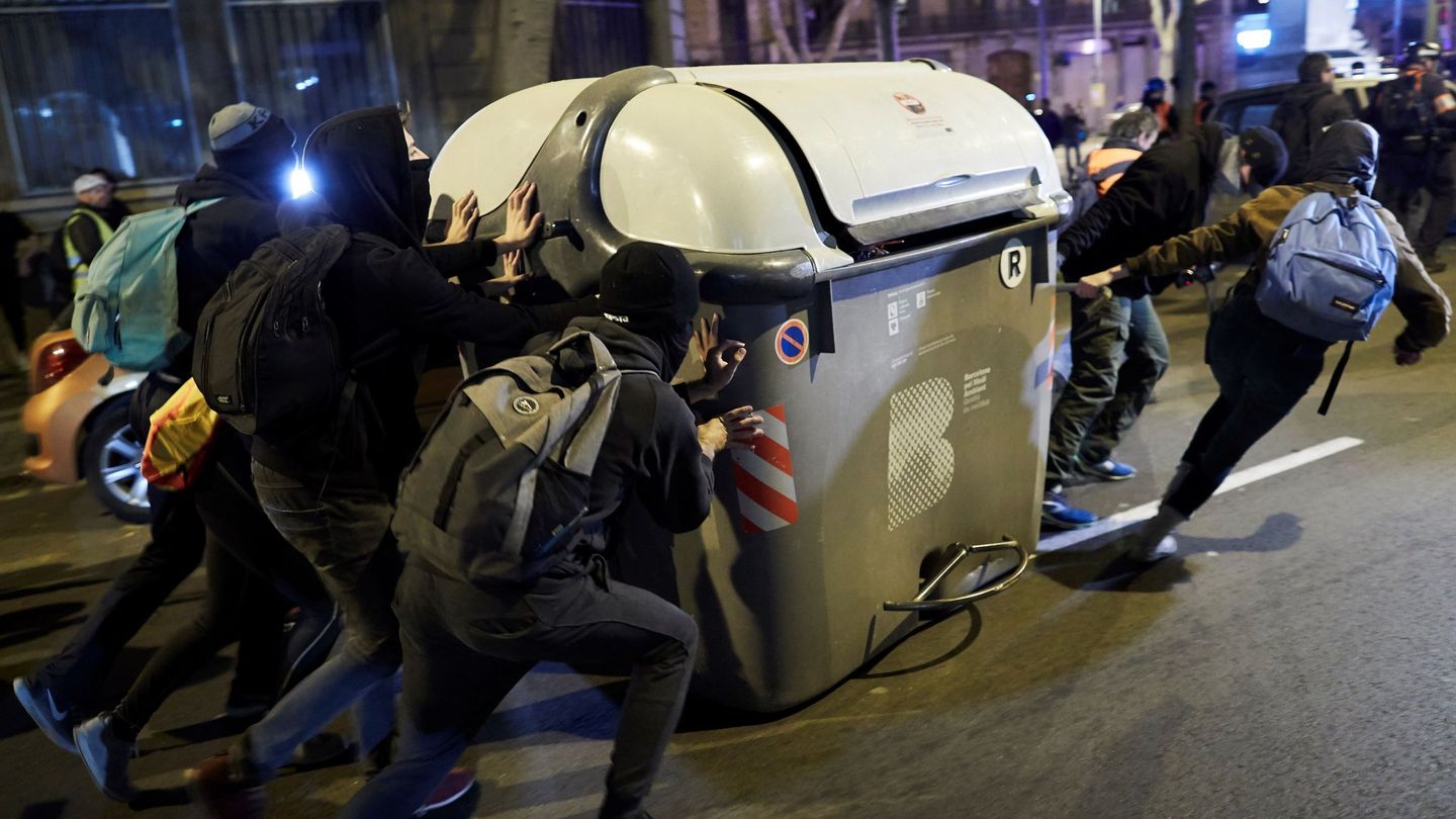 Un grupo de jóvenes empuja un contenedor por las calles de Barcelona. (EFE)