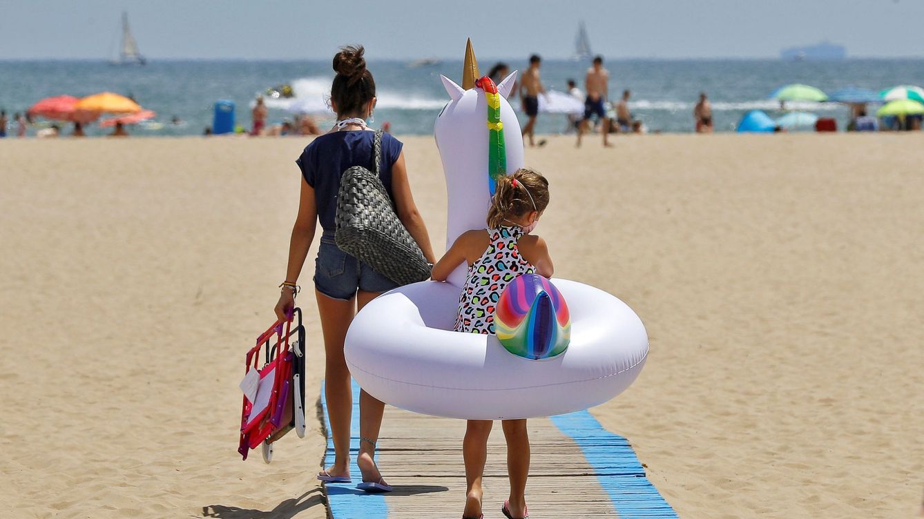 Foto: Una niña se dirige a la playa con un flotador de unicornio. (EFE)