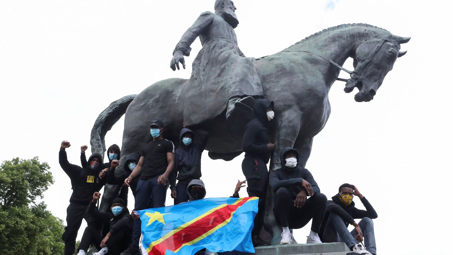 Una protesta en la estatua de Leopoldo II con la bandera de República Democrática del Congo. (Reuters)