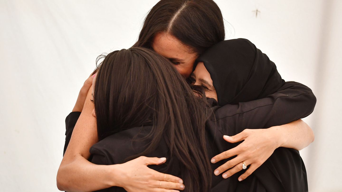 Meghan abrazando a unas mujeres. (Reuters)