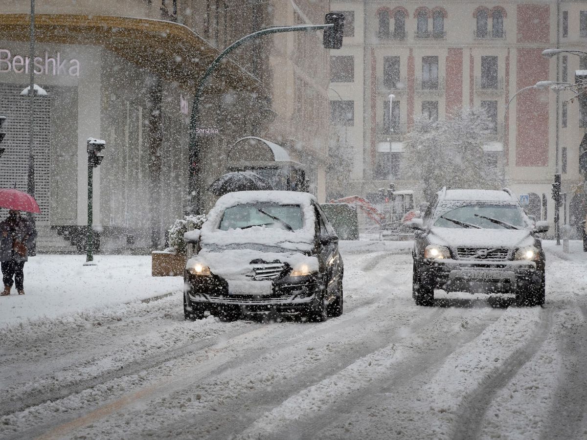 Foto: Dos coches circulan bajo una intensa nevada en Navarra. (EFE/Villar López) 