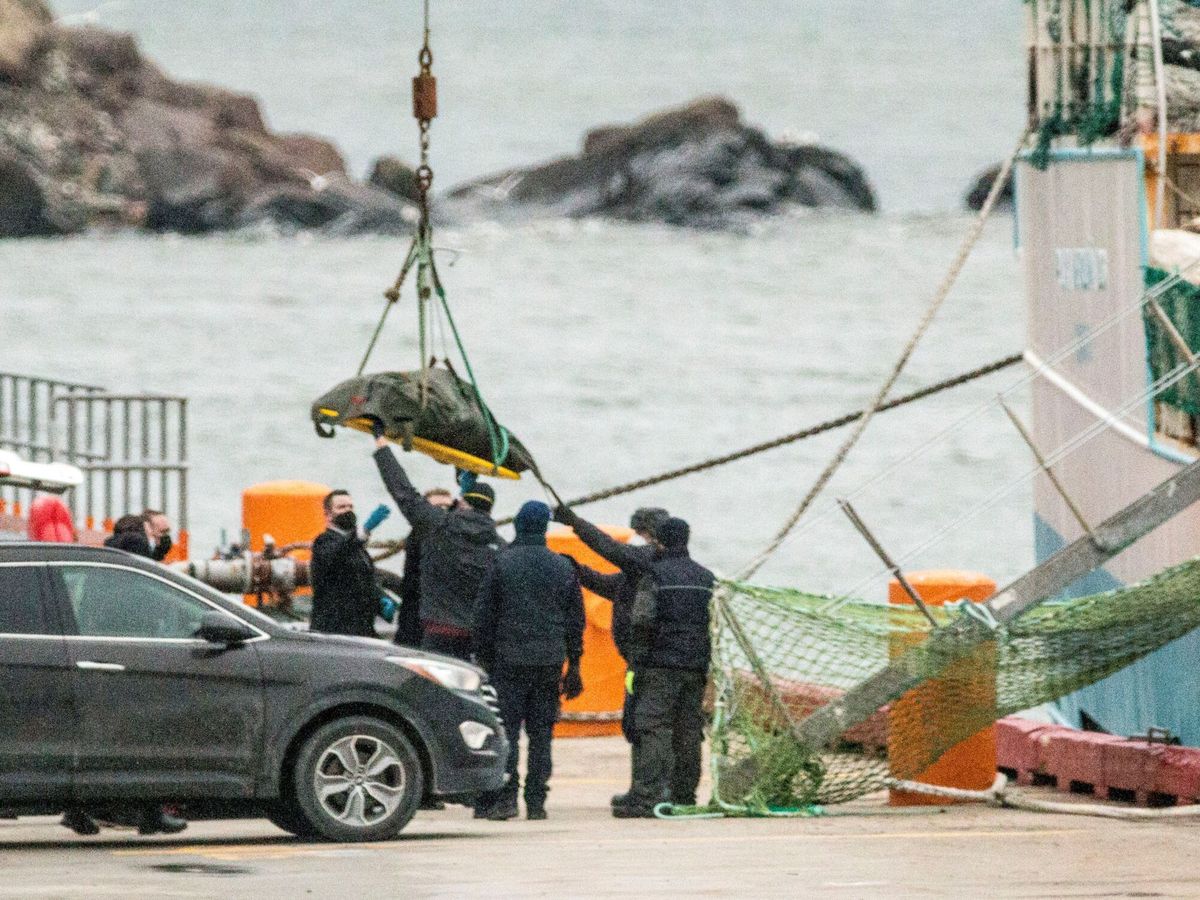 Foto: El cuerpo de uno de los tripulantes fallecidos del Villa de Pitanxo es desembarcado. (EFE/Julio César Rivas)