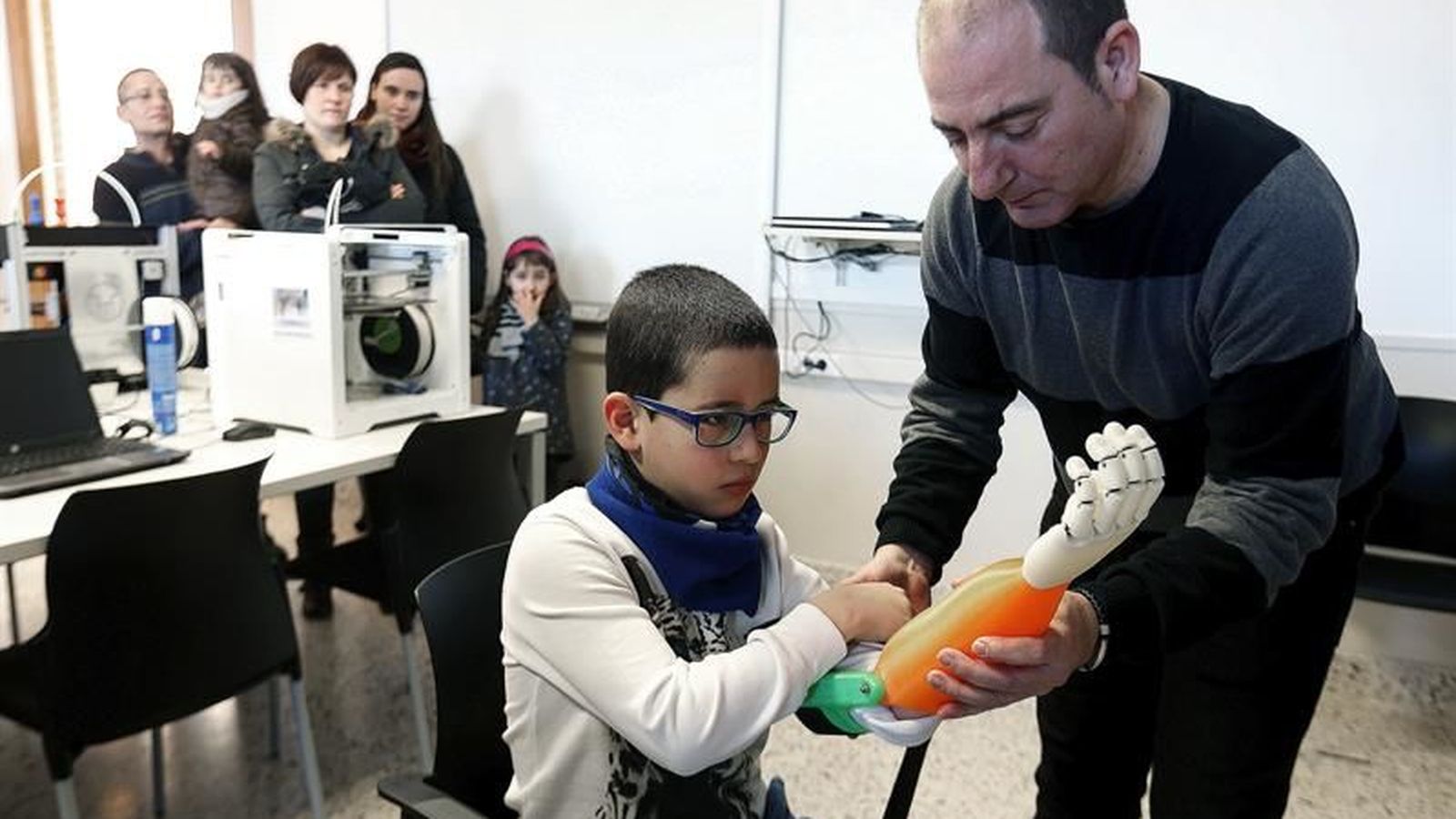 Foto: El profesor Carlos Lizarbe hace entrega a Unai de una prótesis de brazo impresa en 3D