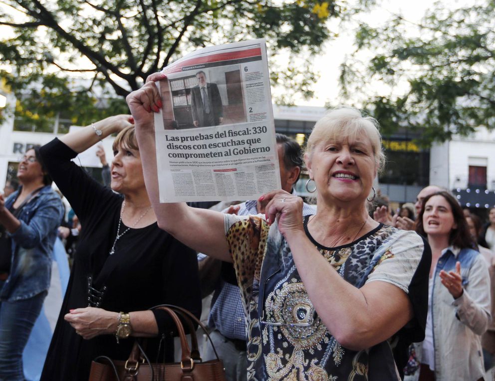 Woman holds up a newspaper with a picture of prosecutor alberto nisman during a protest over his death, in front of the olivos presidential residence in buenos aires