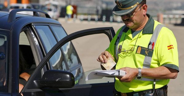 Foto: Un Guardia Civil impone una multa de tráfico a un conductor. (EFE)