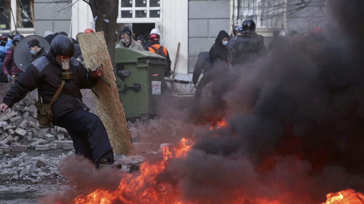 Un opositor se protege con un escudo durante los enfrentamientos en Kiev (Reuters).