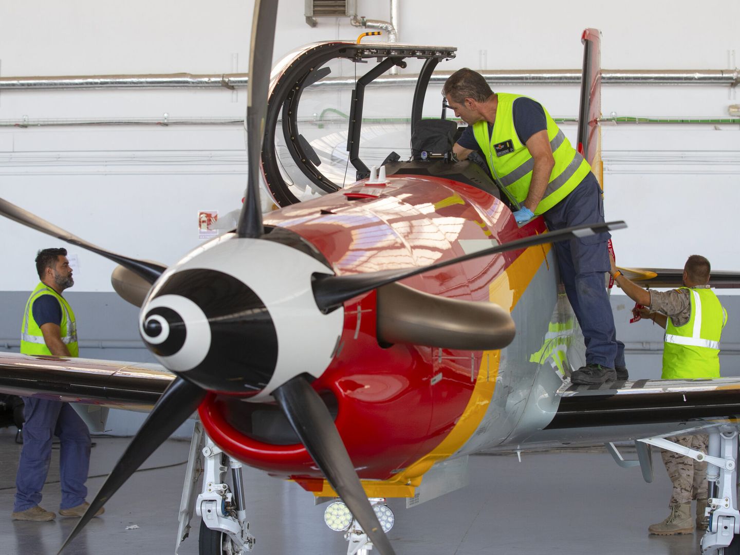 Mecánicos de la Academia General del Aire, durante las labores de mantenimiento de la aeronave Pilatus PC-21. (EFE/Marcial Guillén)