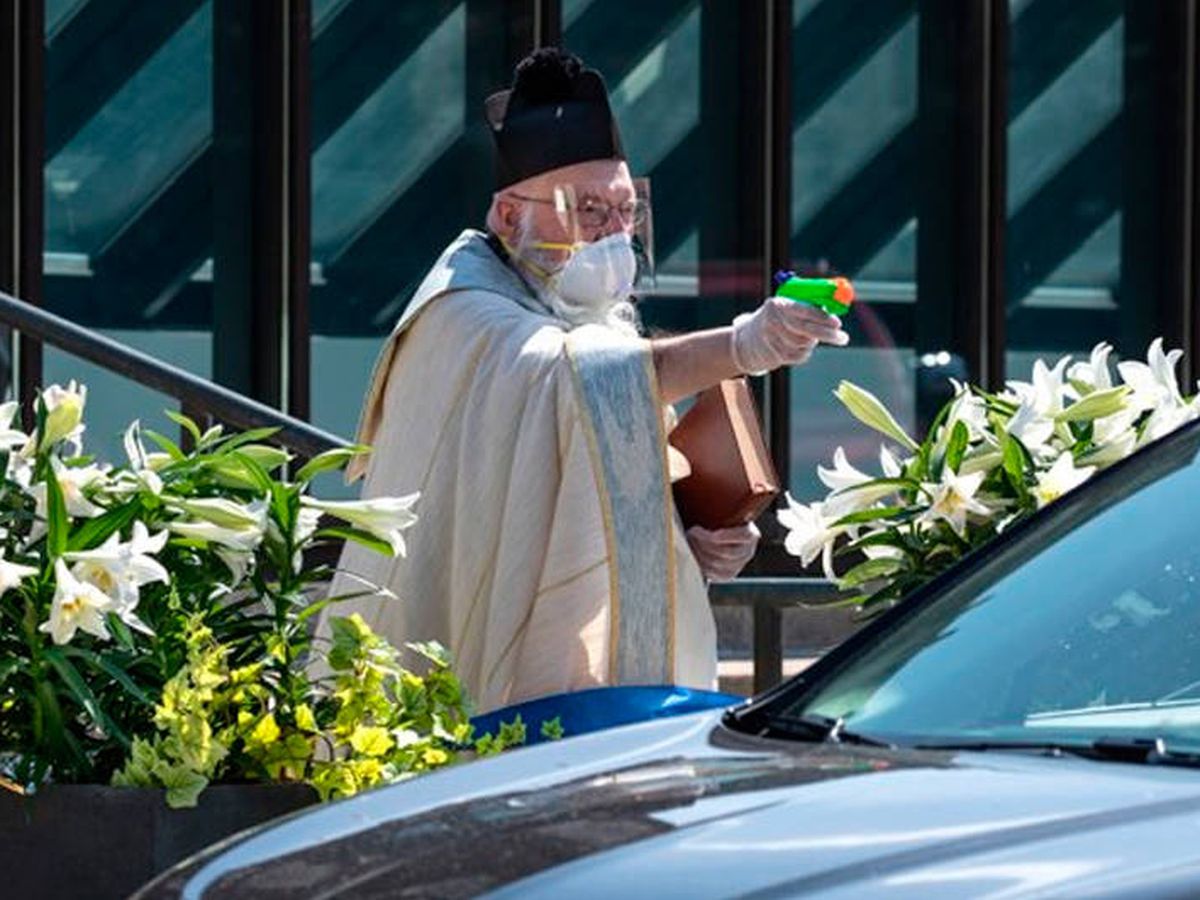 Foto: El Padre Pelc, de 70 años, bendiciendo a sus fieles con una pistola de agua bendita (Foto: Facebook)