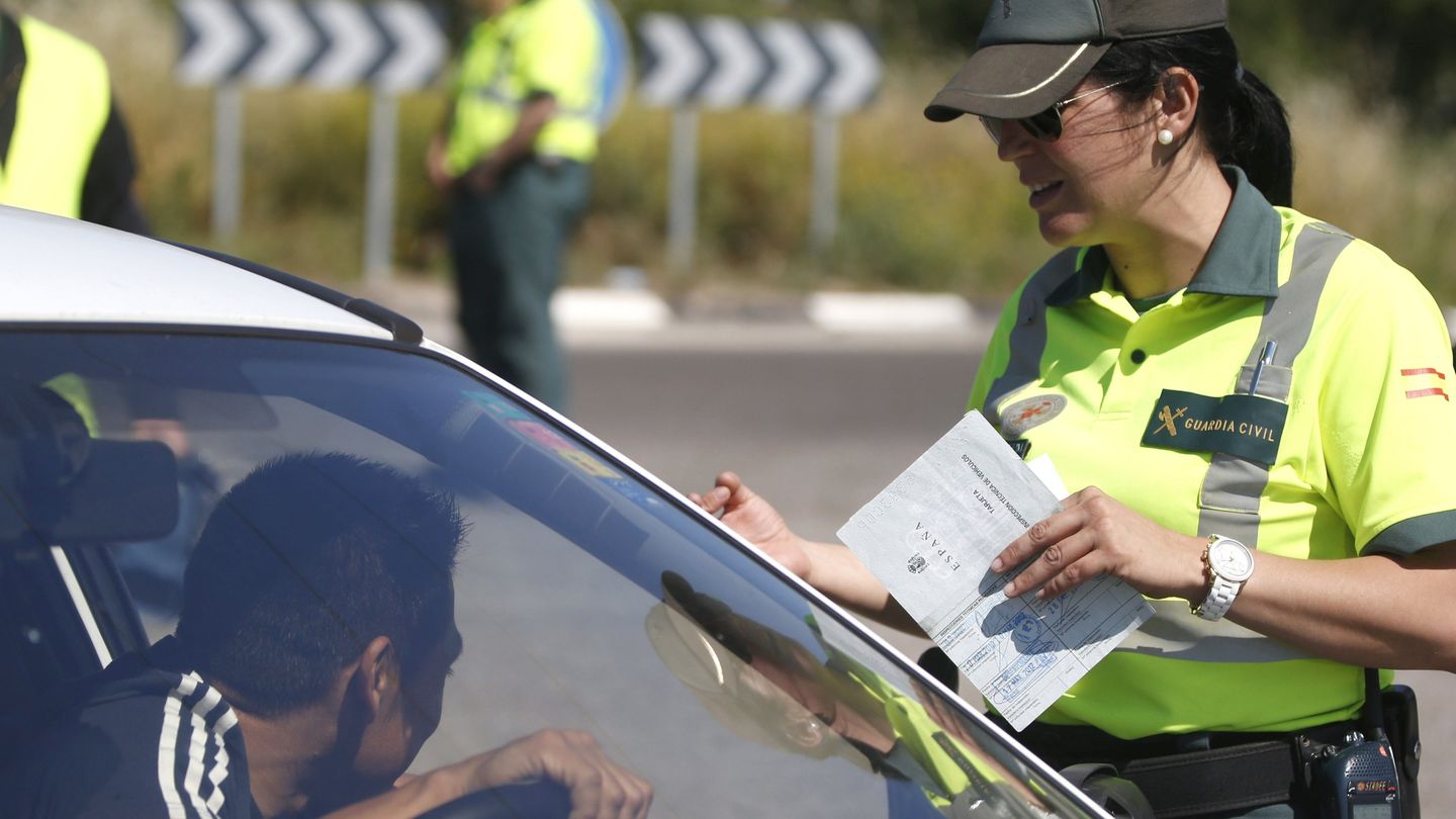 Una agente de la Guardia Civil de Tráfico pide la documentación al conductor de un vehículo. (EFE/Juan Carlos Hidalgo)