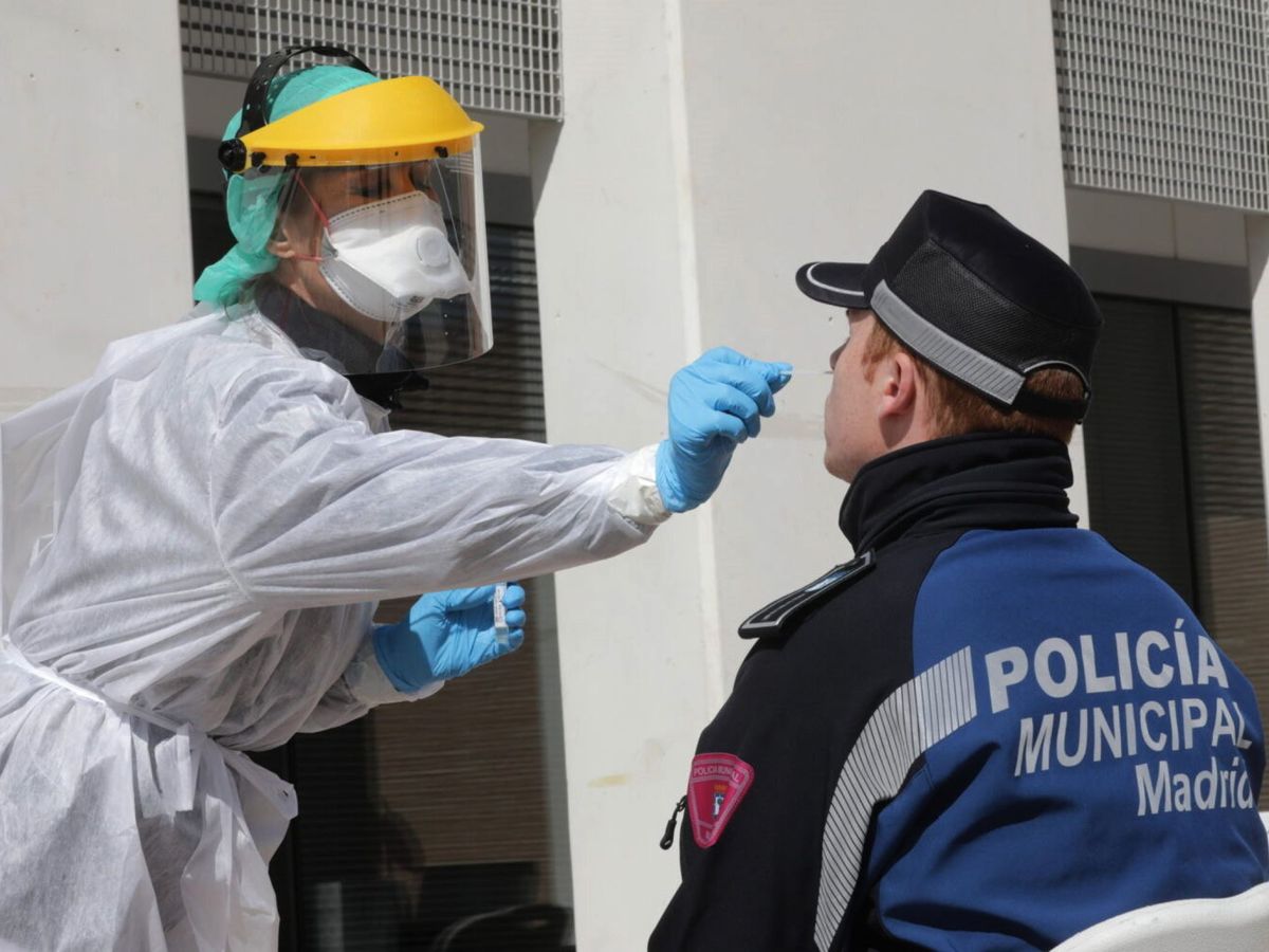 Foto: Un sanitario realiza un test de detección de Covid-19 a un policía municipal de Madrid. (EFE)