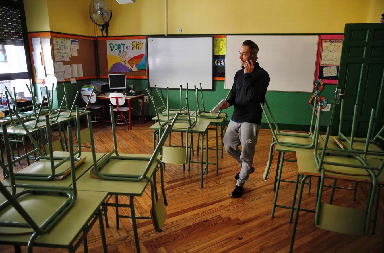Un docente habla por su teléfono móvil en un aula desierta en el colegio público Rufino Blanco en Madrid. (EFE)