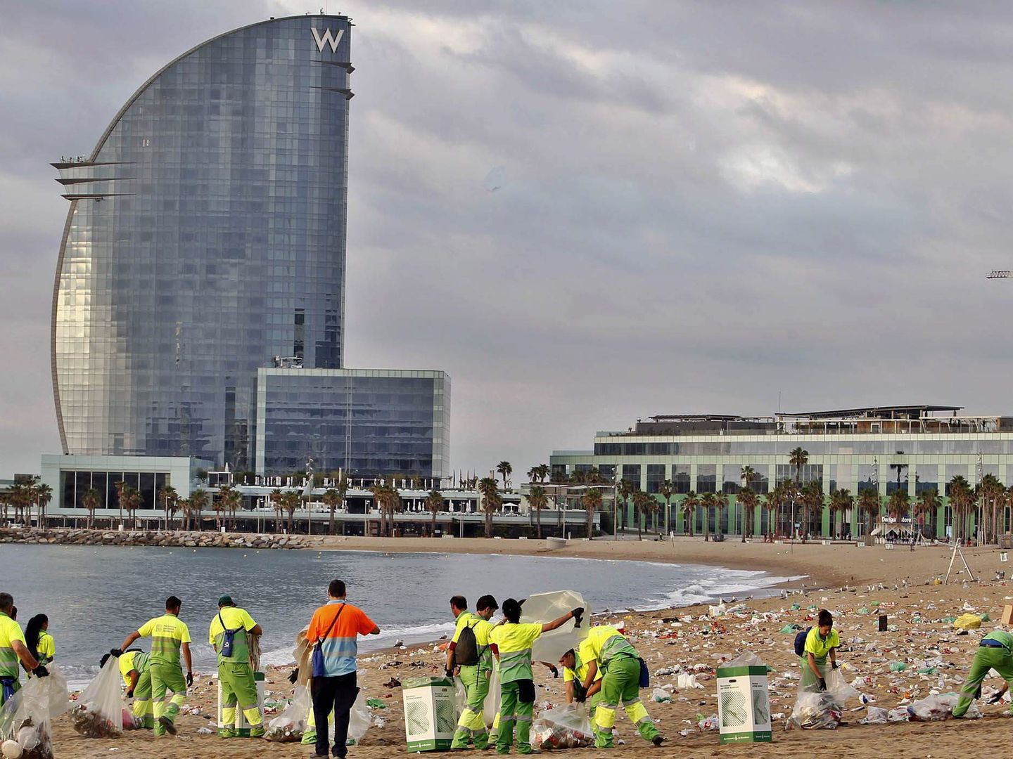 Operarios de limpieza retiran las toneladas de basura acumulada en la playa de la Barceloneta. (EFE)