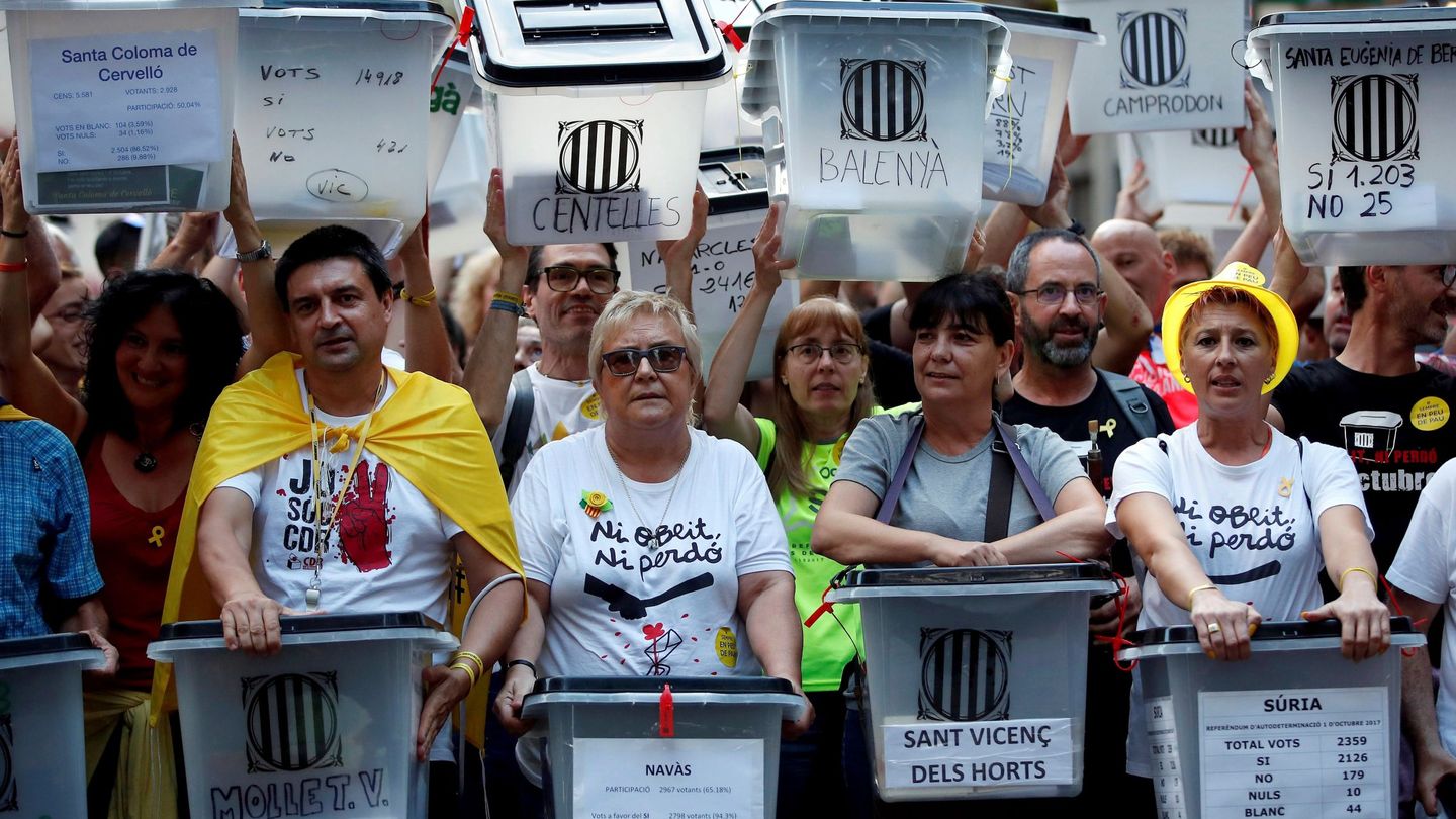 Manifestantes portan urnas en Barcelona con el nombre del municipio al que pertenecen. (EFE)