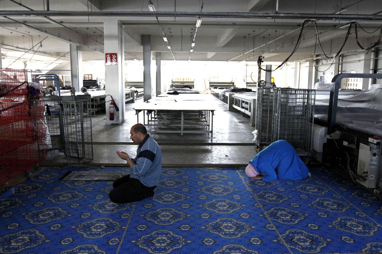 Dos personas rezan en el interior de una fábrica textil cerrada cercana a Rabat (Reuters).