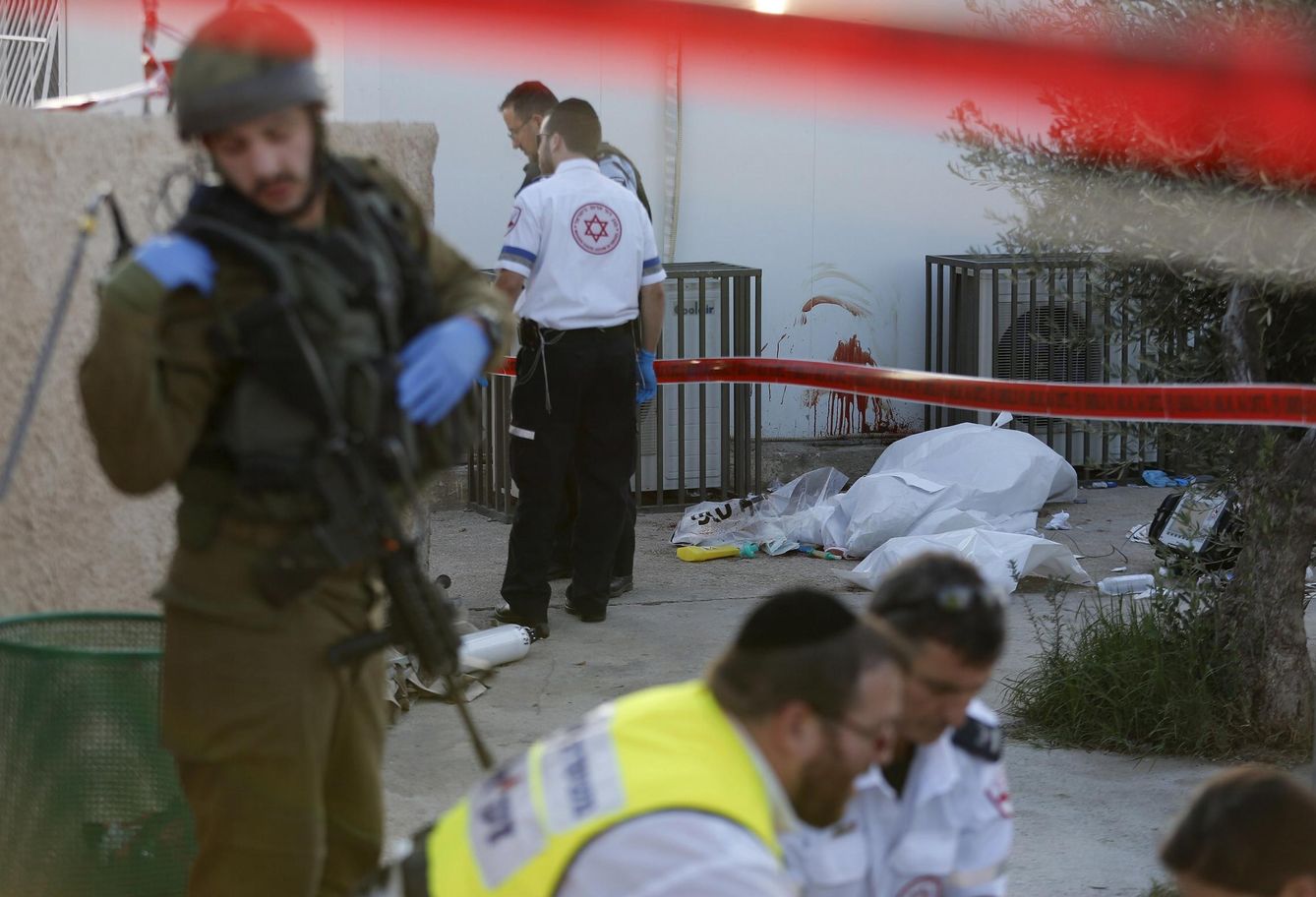 Un soldado israelí y médicos en torno al cadáver de un israelí asesinado por un palestino en Khirbit Al-Misbah, Cisjordania (Reuters). 