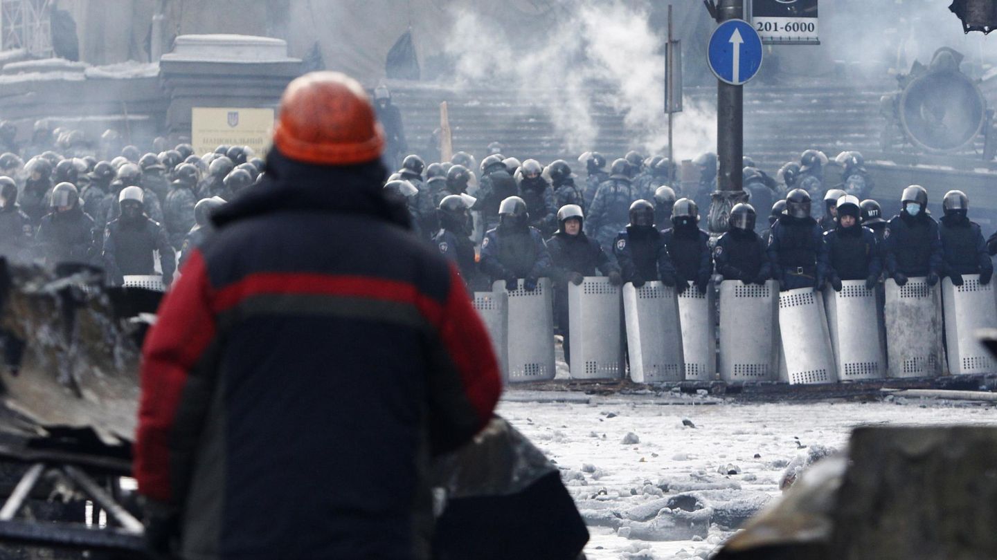 Un manifestante observa a los antidisturbios en Kiev (Reuters).