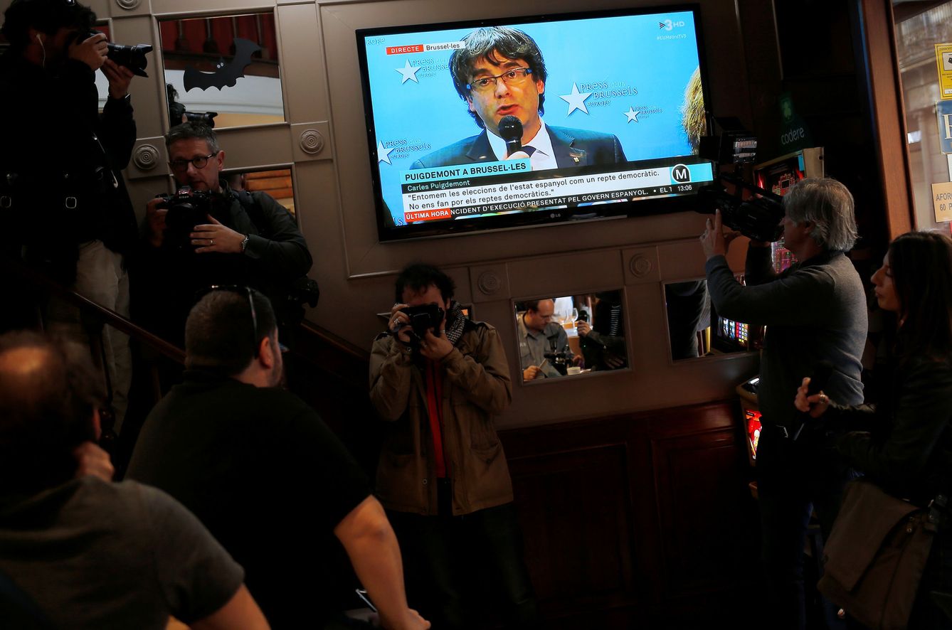 Un grupo de barceloneses sigue la comparecencia de Carles Puigdemont desde Bruselas en un bar. (Reuters)