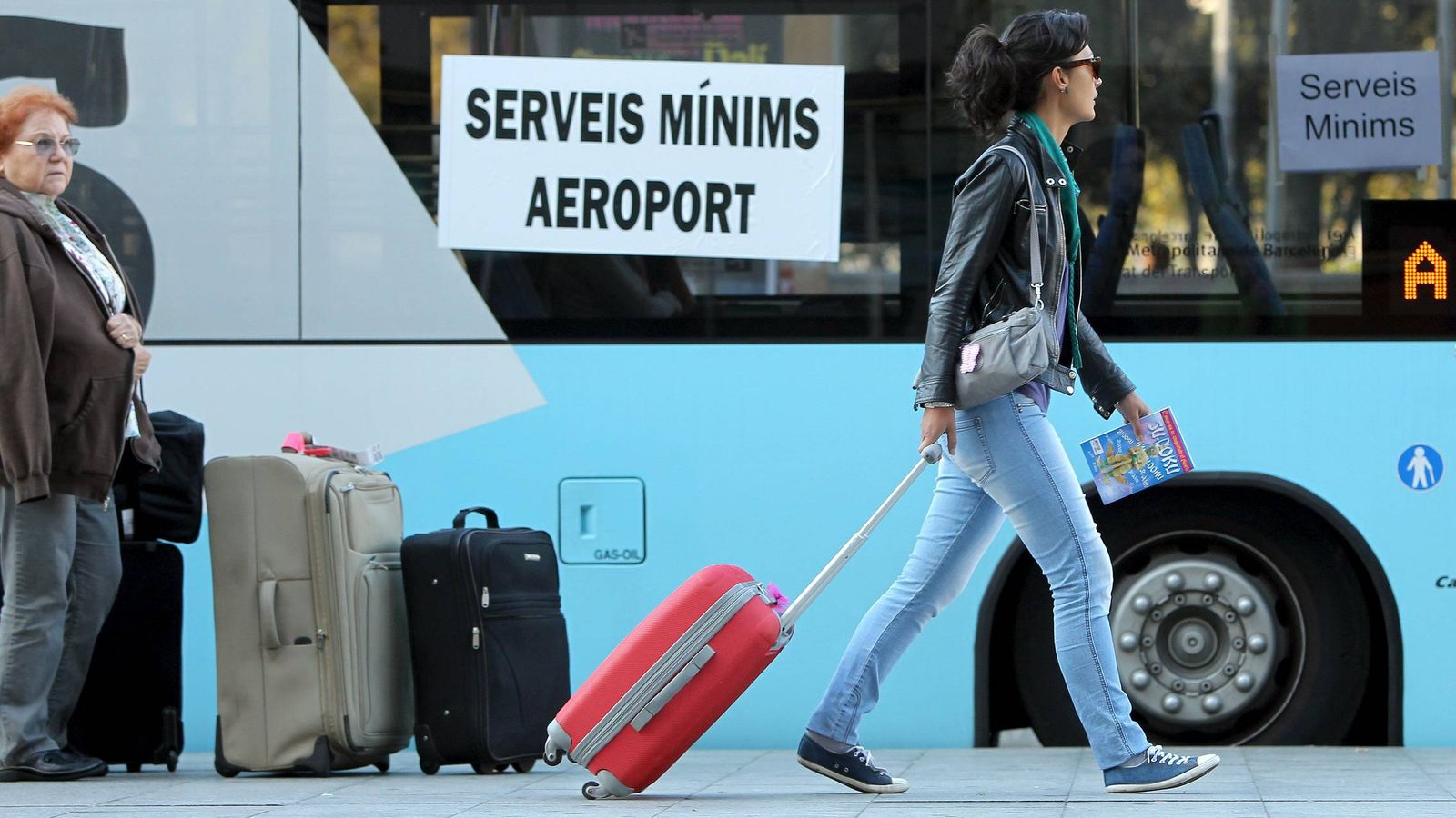 Foto:  Una joven se dispone a subir a un autobus de servicios mínimos para ir al aeropuerto del Prat. (EFE)
