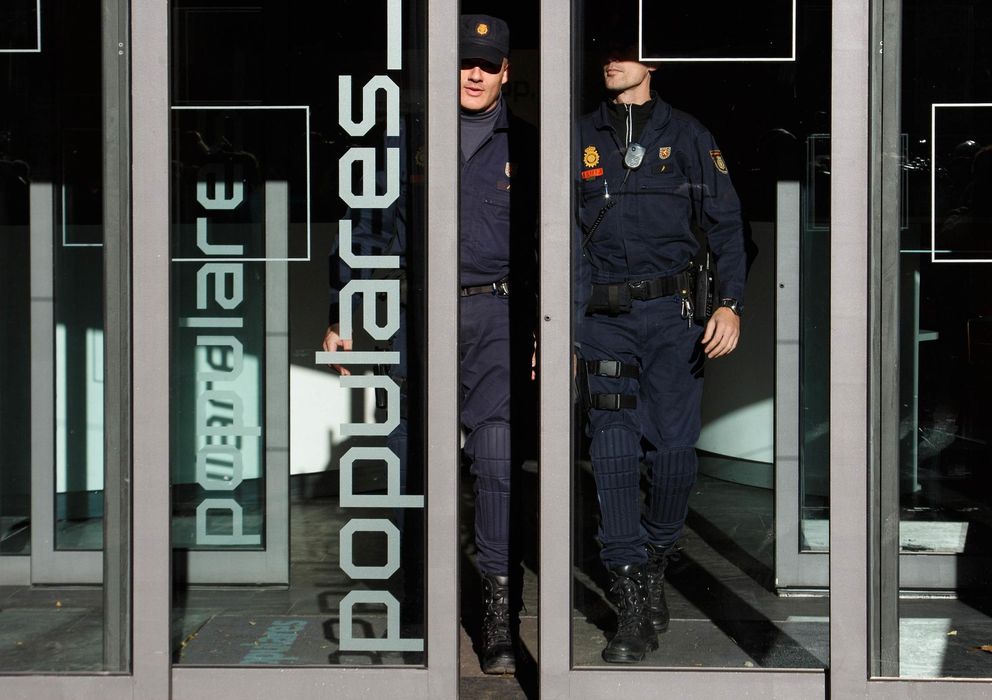 Foto: Dos policías salen de la sede del PP en la calle Génova de Madrid. (Reuters).